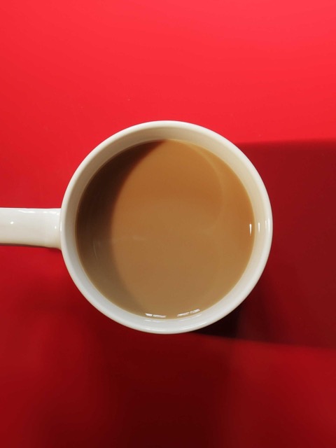 A cup of coffee on a bright red table